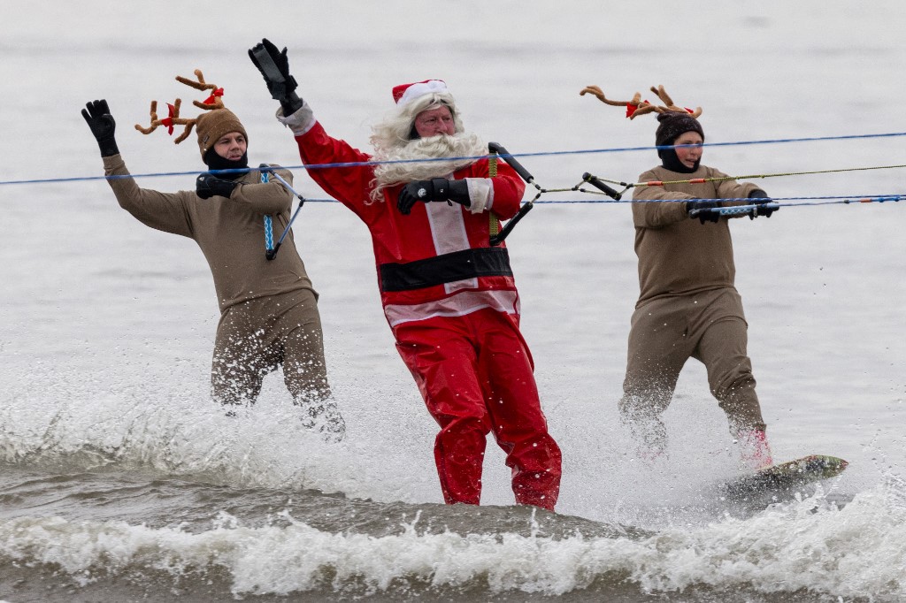 Papás Noel surfistas toman una playa de Florida por diversión y una buena causa
